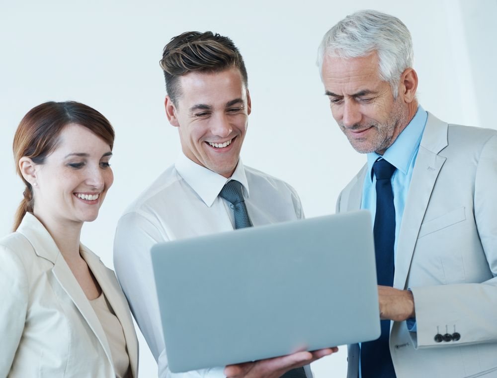 Three colleagues looking at a laptop together