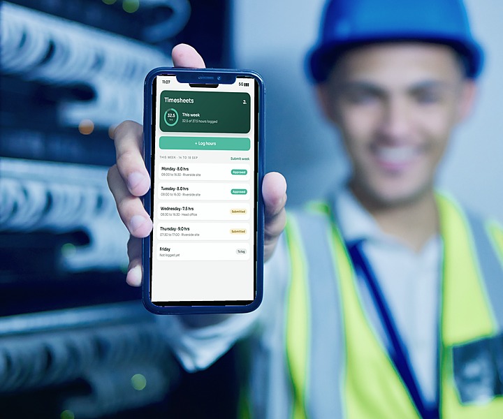 A technician in hi-vis holding up his phone showing the Jamie HR timesheet